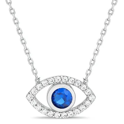 A silver-tone evil eye pendant necklace featuring a round blue center stone surrounded by a halo of small clear stones, suspended from a delicate silver chain on a white background.