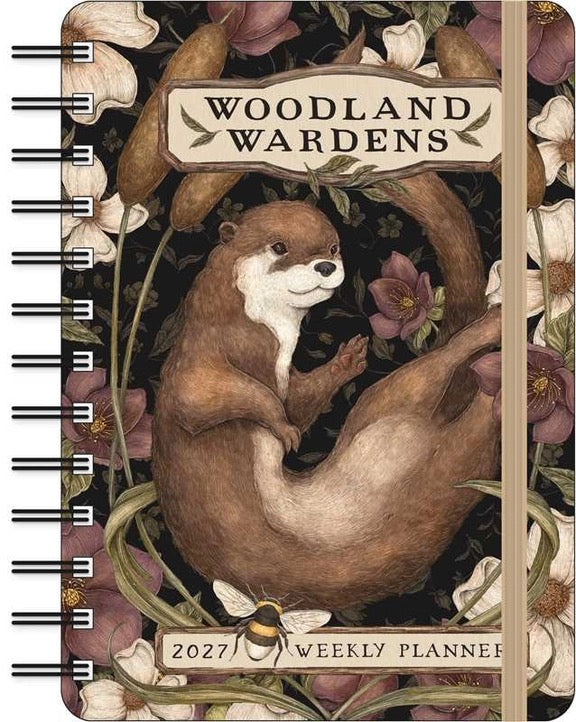 Woodland Wardens 2027 Weekly Planner with a spiral binding on the left. The cover features an illustration of an otter curled up among flowers and vines, with a dark background and a light wood-toned spine.
