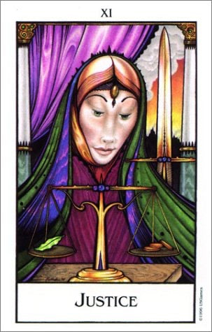 Justice tarot card, showing a woman in a purple and green cloak with a golden scale of justice in the foreground and a sword behind her. The card is labeled 'XI' at the top and 'JUSTICE' at the bottom.