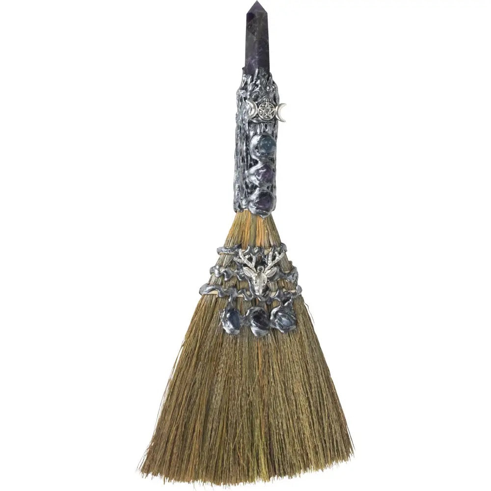 Decorative broom with silver embellishments on a white background