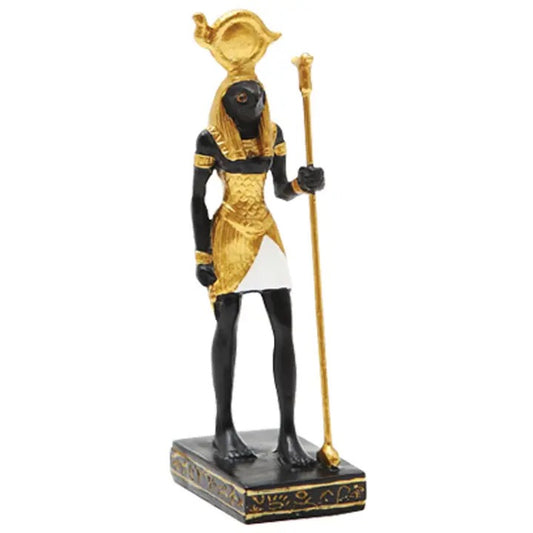 An Egyptian goddess figurine with a black body, gold headdress and skirt details, holding a gold staff, standing on a black base with gold accents against a white background.