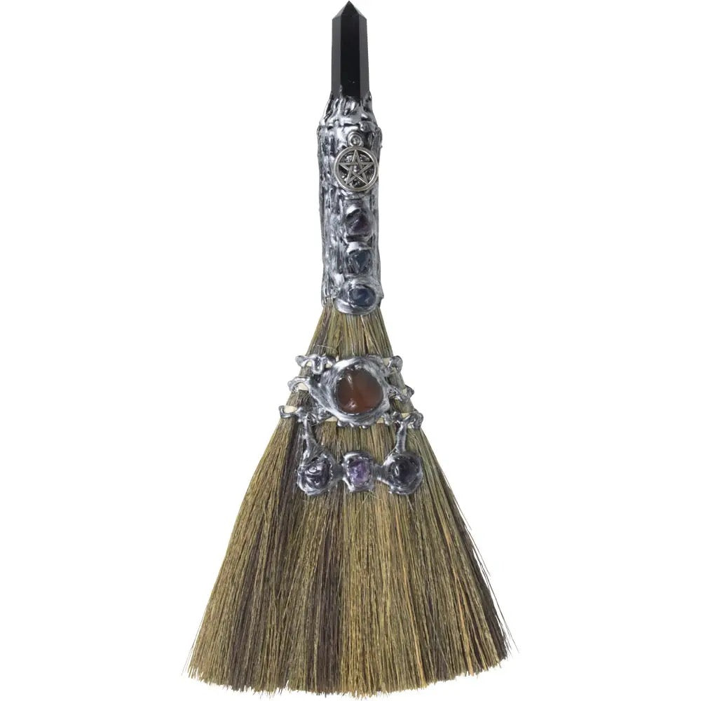 Decorative broom with embellishments on a white background