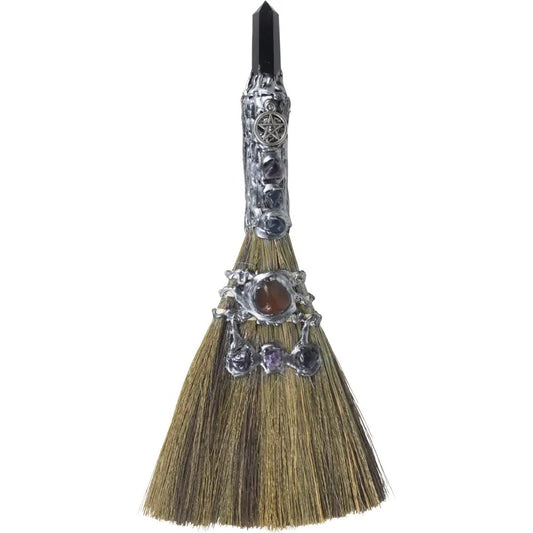 Decorative broom with embellishments on a white background