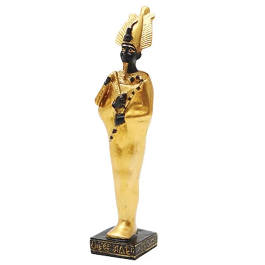 An ancient Egyptian pharaoh figurine styled in gold and black, standing on a decorative black base with hieroglyphic details, set against a plain white background.