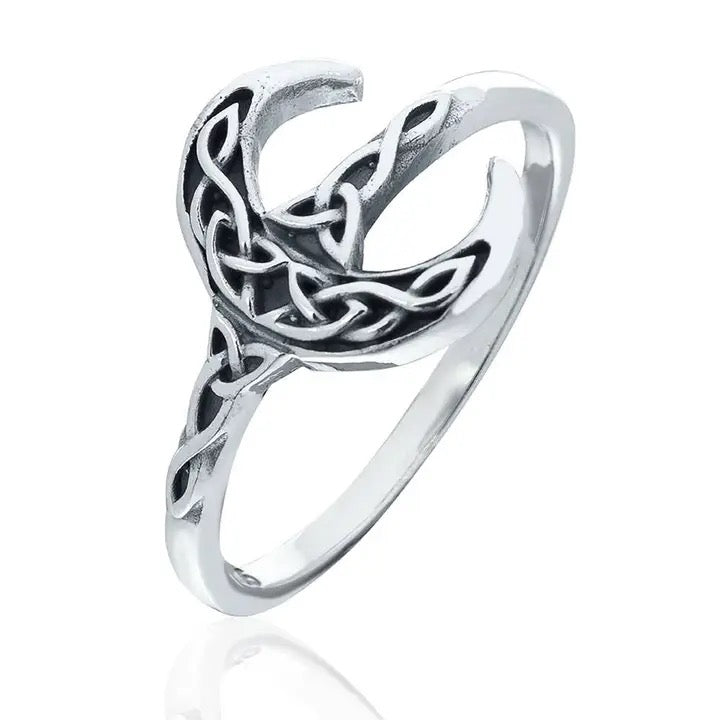 Silver ring with intricate design on a white background