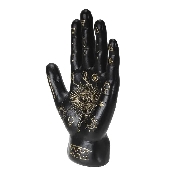 Black decorative hand with gold symbols on a white background