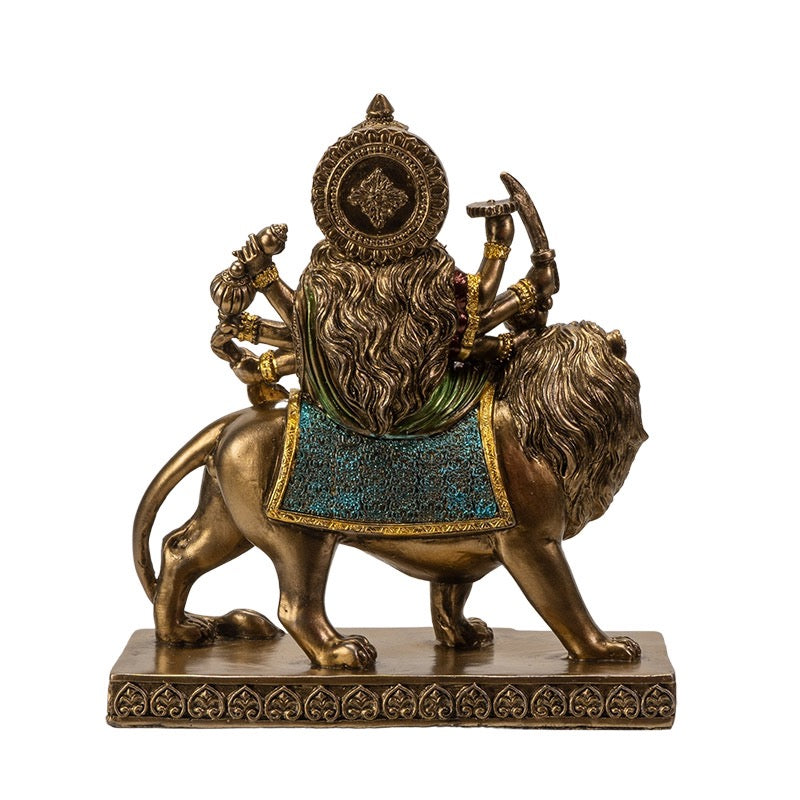 Statue of a multi-armed deity on a lion with intricate details on a white background