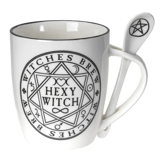 White ceramic mug with a black rim and a black printed pentagram and 'Witches Brew' design, accompanied by a matching white spoon featuring a black pentagram symbol.