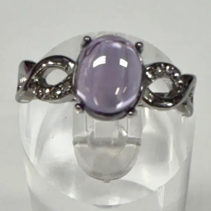 Ring with a purple gemstone and silver accents on a white background