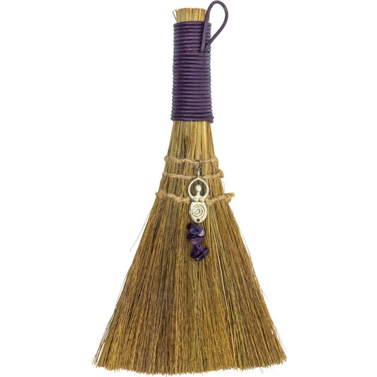 Decorative broom with a purple handle and decorative elements on a white background