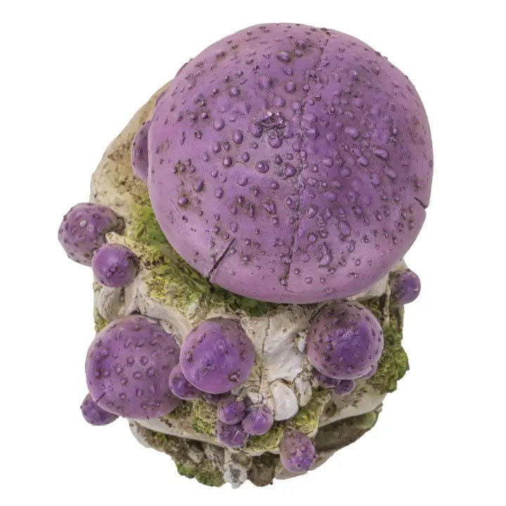 A decorative mushroom statue featuring a large purple cap with textured bumps on top, surrounded by smaller purple mushrooms and green mossy details on a beige and white base, isolated on a white background.