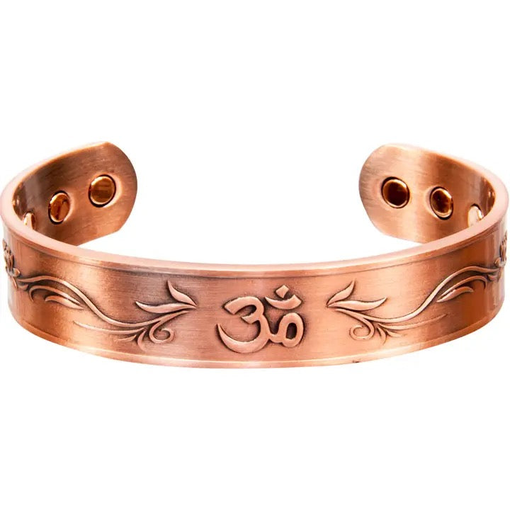 Copper bracelet with engraved design and 'Om' symbol on a white background