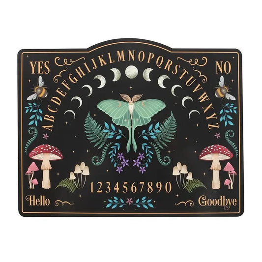 A decorative spirit board with a black background, gold lettering, and whimsical illustrations including a large green moth, crescent moons, bees, mushrooms, flowers, and numbers, shown on a plain white background.