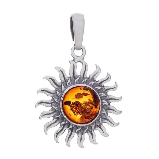 A sterling silver sun pendant featuring a round amber center, set against a plain white background.