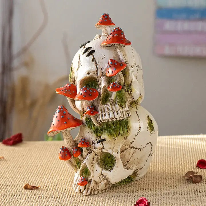 Decorative skull with red mushrooms on a textured surface