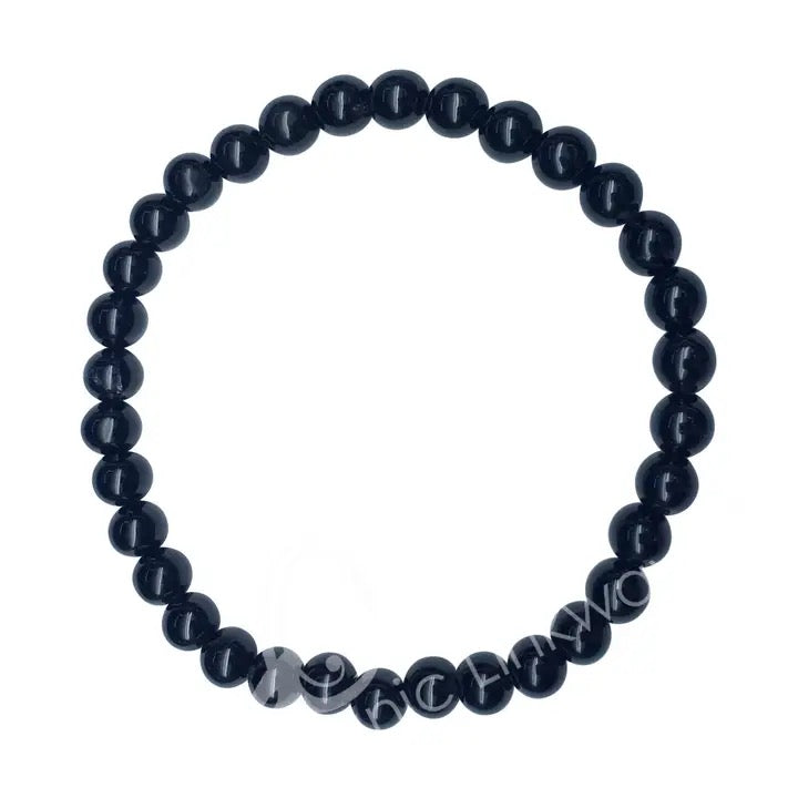 Black beaded bracelet with engraved text on a white background