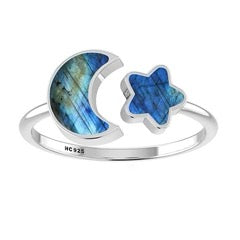 Silver ring with blue stone in the shape of a moon and star on a white background
