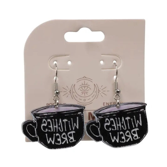 Black teacup earrings with 'Witches Brew' text on a beige card