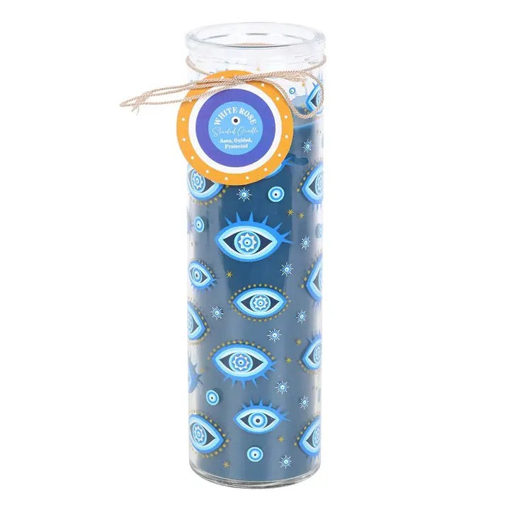 A tall glass jar candle with blue patterned wax featuring repeated blue and white eye motifs, tied with a twine bow and a round paper label that reads 'Holy Eye Candle'.
