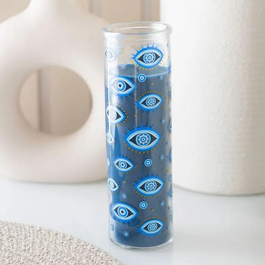 Glass candle holder with blue eye pattern on a white surface
