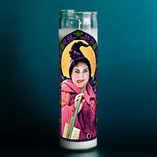 Candle with a colorful design featuring a person in a pink outfit and yellow hat on a dark teal background.