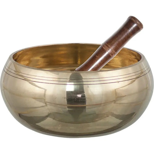 A brass singing bowl with a dark brown wooden mallet resting inside, shown against a plain white background.