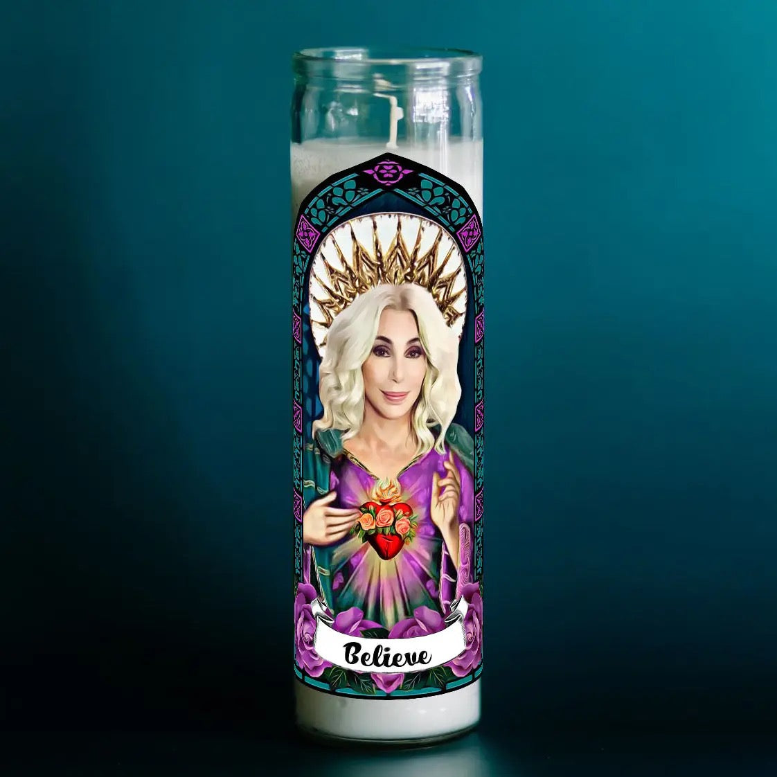 Candle with a religious-themed design featuring a face and 'Believe' text on a teal background