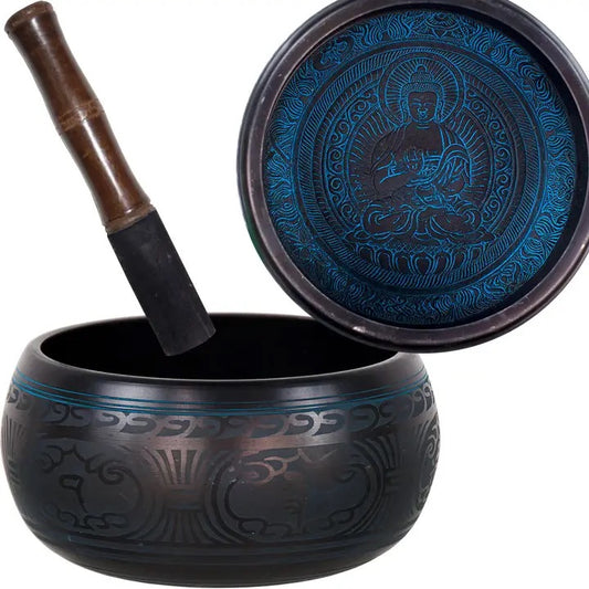 Tibetan singing bowl with decorative patterns and a wooden handle on a white background