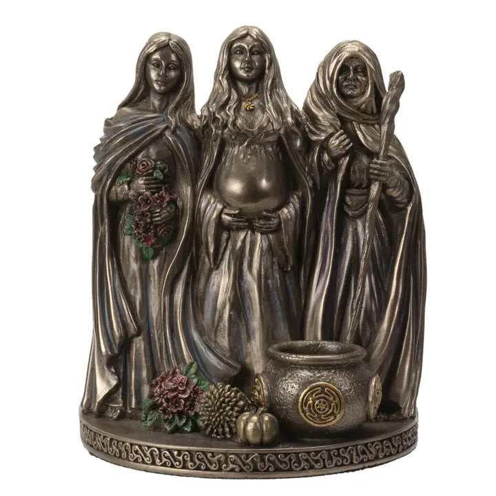 Statue of three hooded figures with a cauldron and ingredients on a white background
