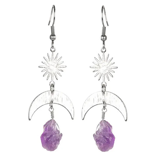 Pair of earrings with purple stones and star and moon designs on a white background