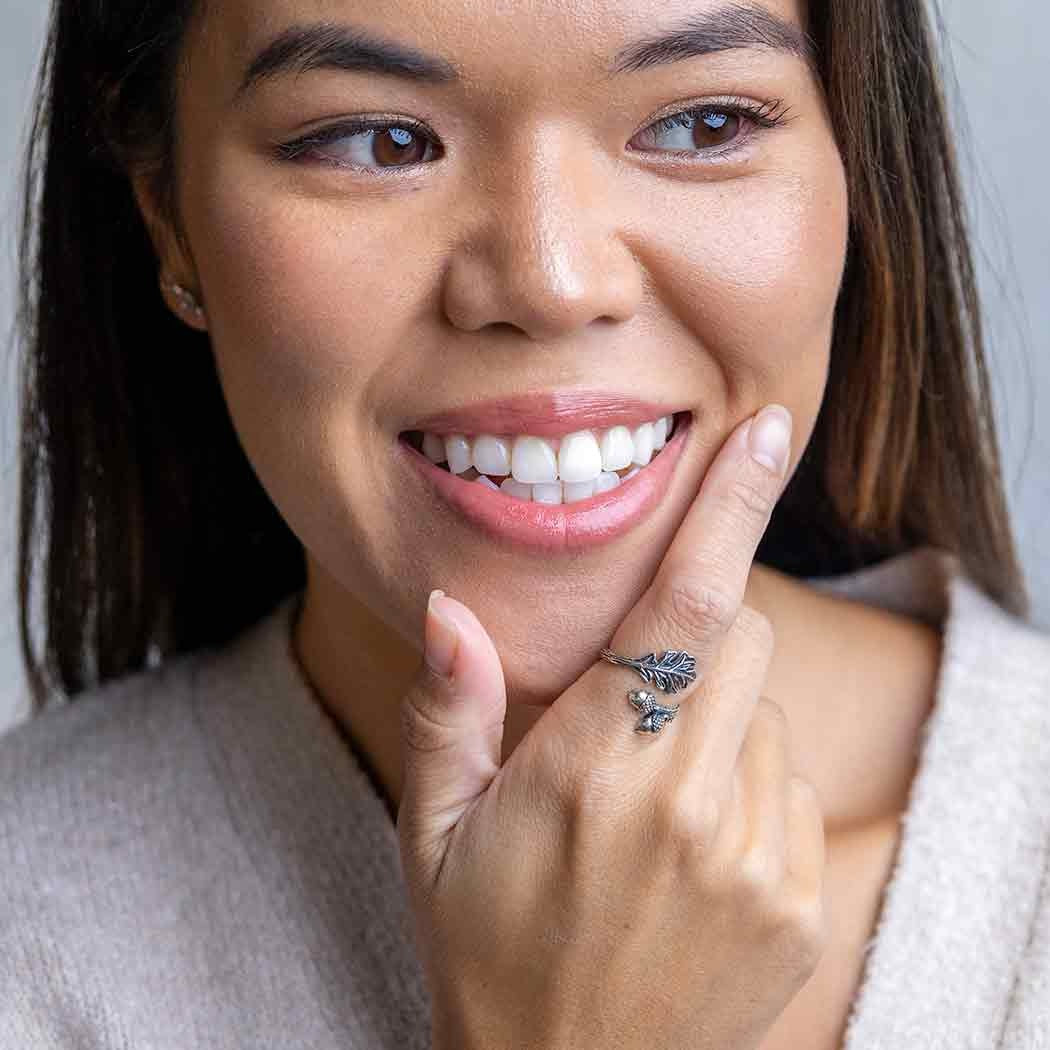 Woman wearing a ring with a Ring Acorn on her finger, smiling.
