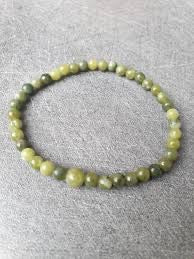 Green beaded bracelet on a gray background