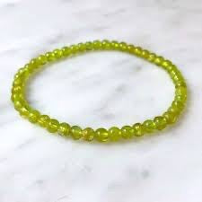 Green beaded bracelet on a marble surface