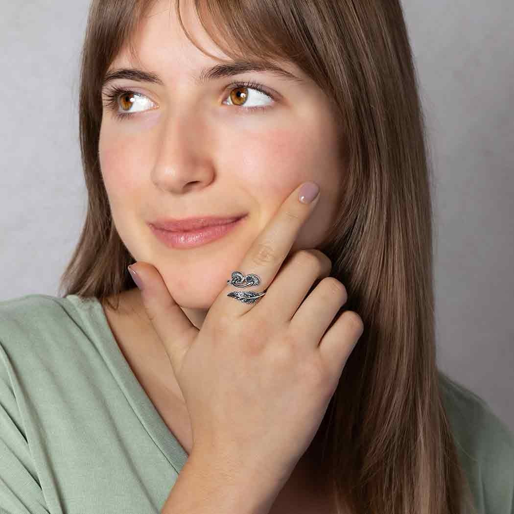 Woman wearing a silver ring with a Mushroom & Fern design, touching her face against a neutral background
