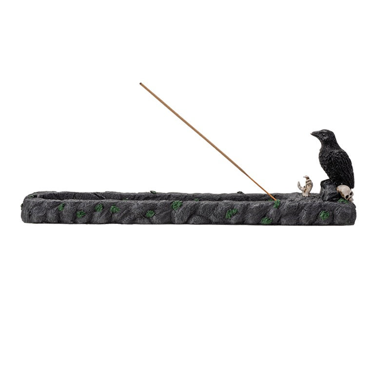 A incense burner, crow, and an incense  stick on a white background