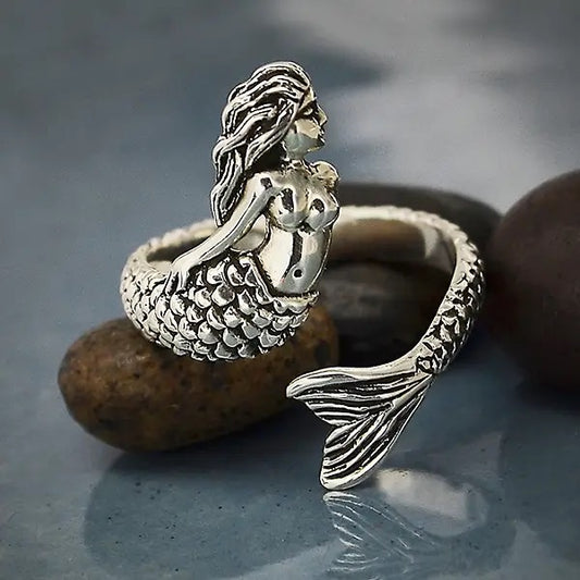 Silver mermaid ring on a stone surface