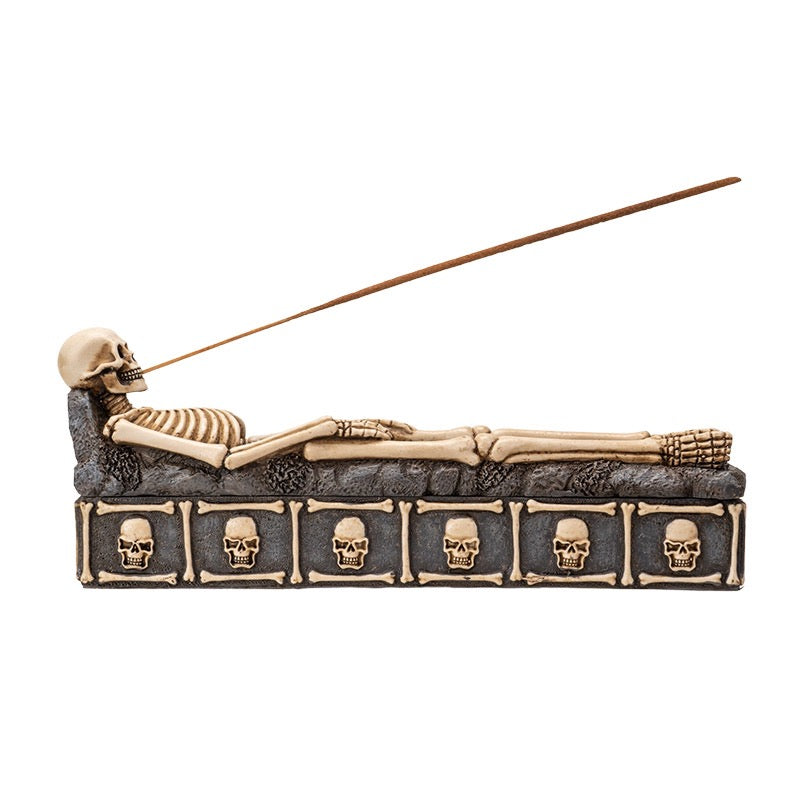 Incense burner with skeleton design and skull patterns on a white background