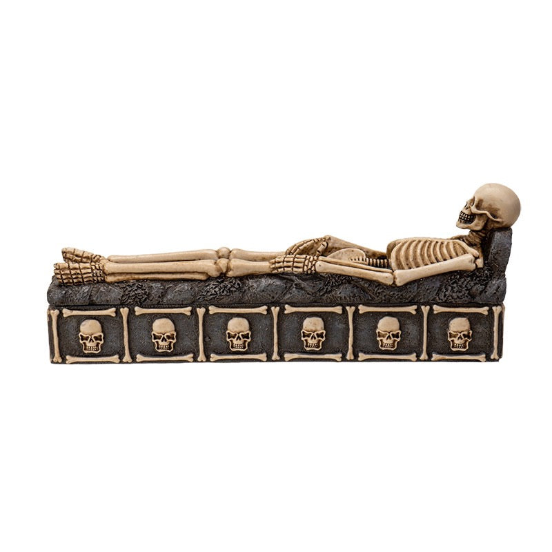 Incense burner with skeleton design and skull patterns on a white background