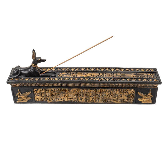 Decorative incense burner with Egyptian hieroglyphics and a burning stick on a white background