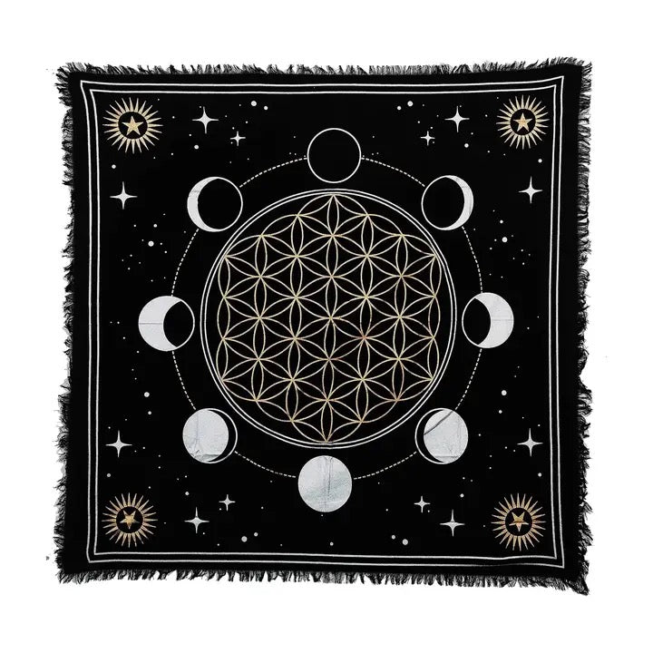 A square black altar cloth with fringe edges, featuring a white and gold celestial design with the Flower of Life, moon phases, stars, and sun motifs on a white background.