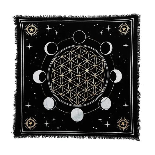 A square black altar cloth with fringe edges, featuring a white and gold celestial design with the Flower of Life, moon phases, stars, and sun motifs on a white background.