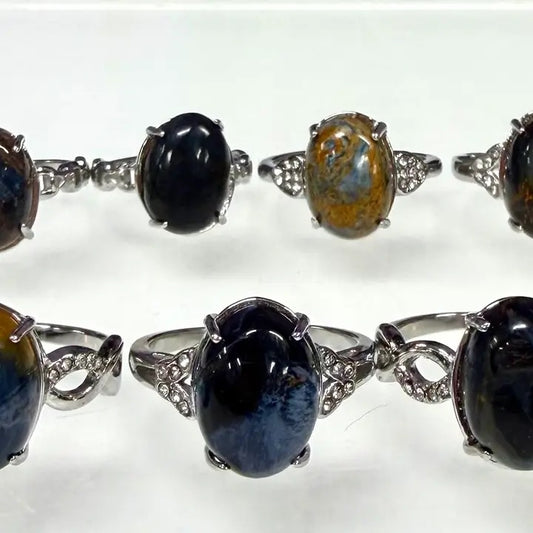 Set of silver rings with various colored gemstones on a white background