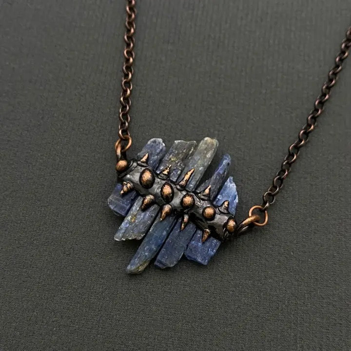 Necklace with blue stone pendant on a dark gray background