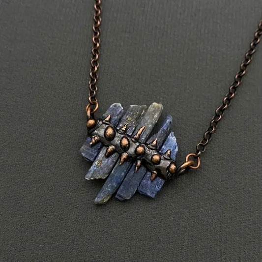 Necklace with blue stone pendant on a dark gray background