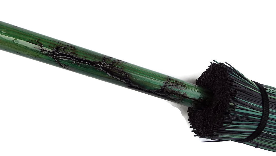 Green broom handle with black bristles on a white background