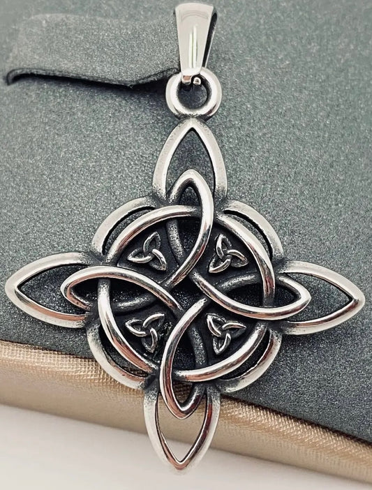 Silver Celtic knot pendant on a stone surface
