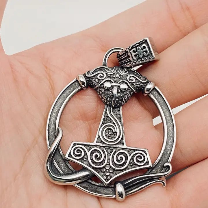 Silver Thor's hammer pendant held in a hand