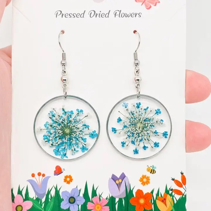 Round earrings with pressed dried flowers on a floral-themed card