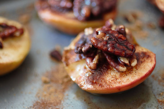 Apples with pecans and cinnamon on a baking sheet