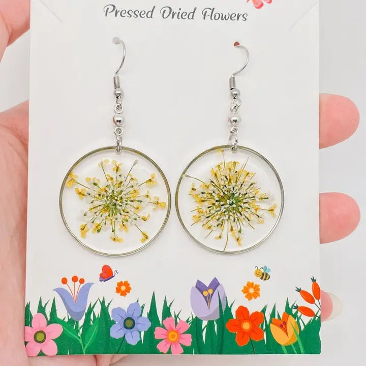 Pressed dried flowers earrings on a decorative card with floral design